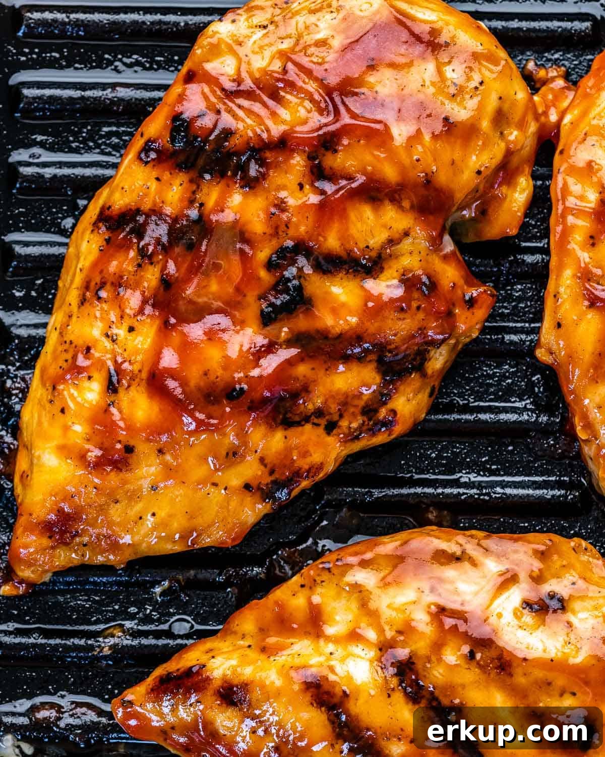 barbecue sauce on chicken breasts on grill pan