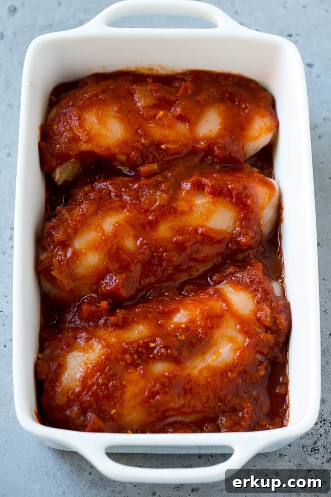 Chicken breasts in a baking dish coated with salsa.