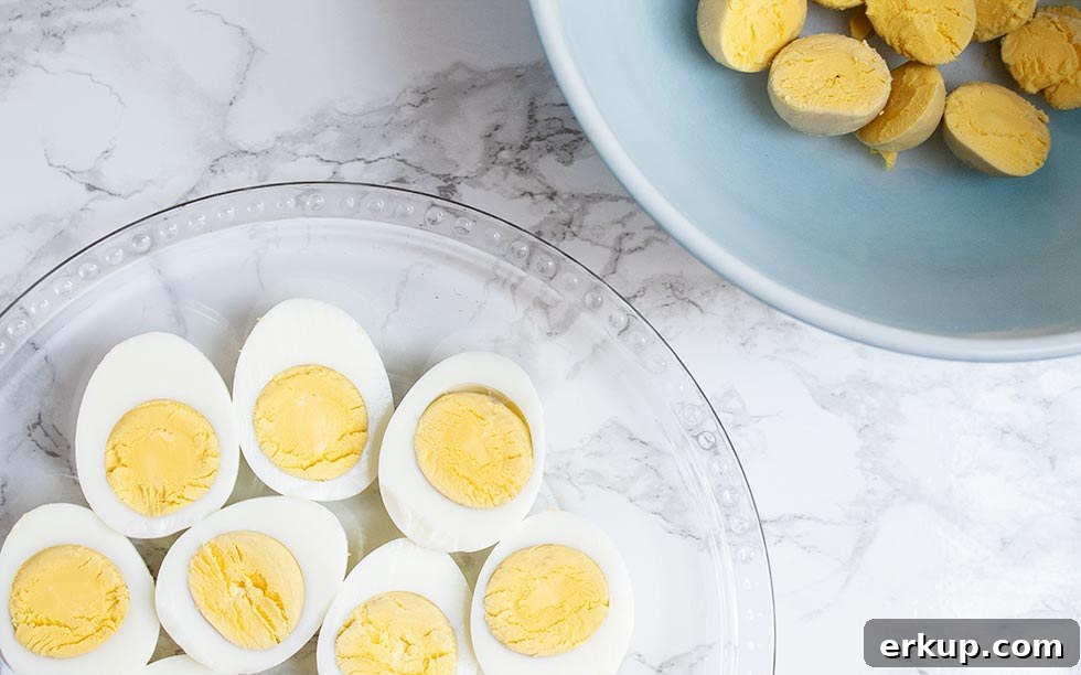 Keto Deviled Eggs with Everything Bagel Seasoning Recipe 4 eggs with some yolks removed in a bowl to be used in keto deviled eggs