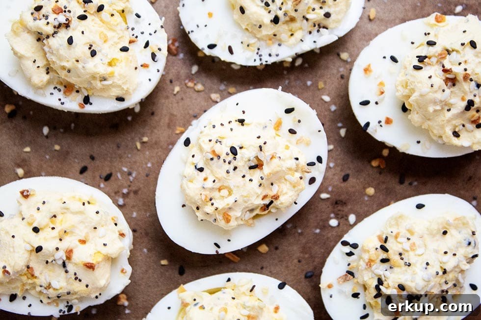 Keto Deviled Eggs with Everything Bagel Seasoning Recipe 7 seven keto deviled eggs on a baking sheet with seasoning sprinkled on top
