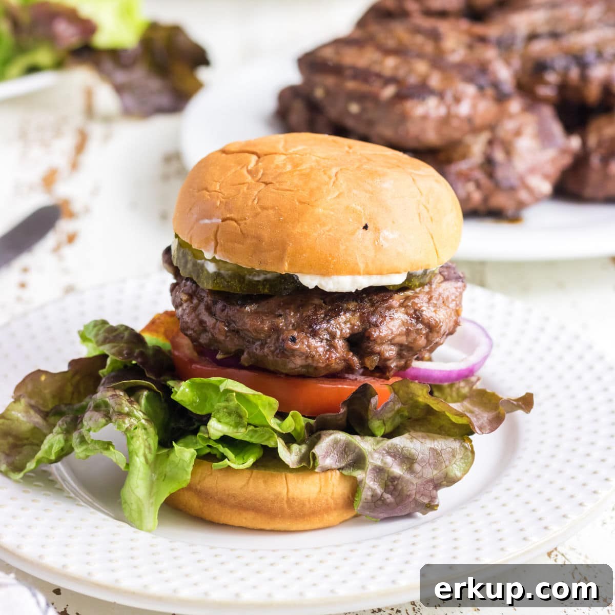 Closeup of a finished hamburger in a bun.