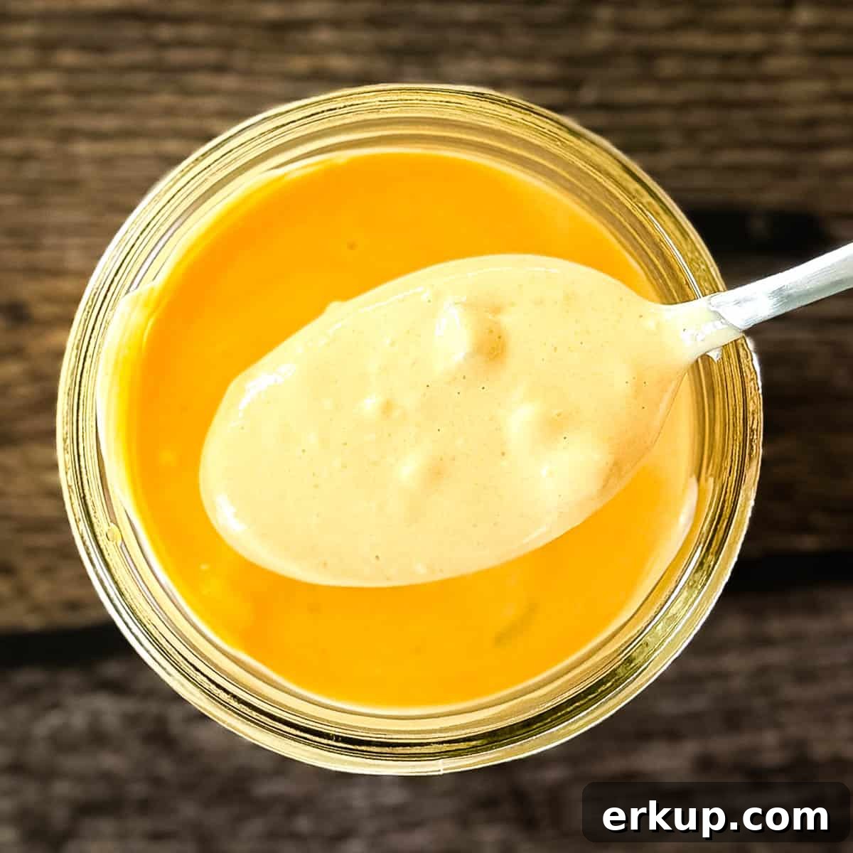 Homemade burger sauce in a small mason jar, with visible small chunks of diced pickles.