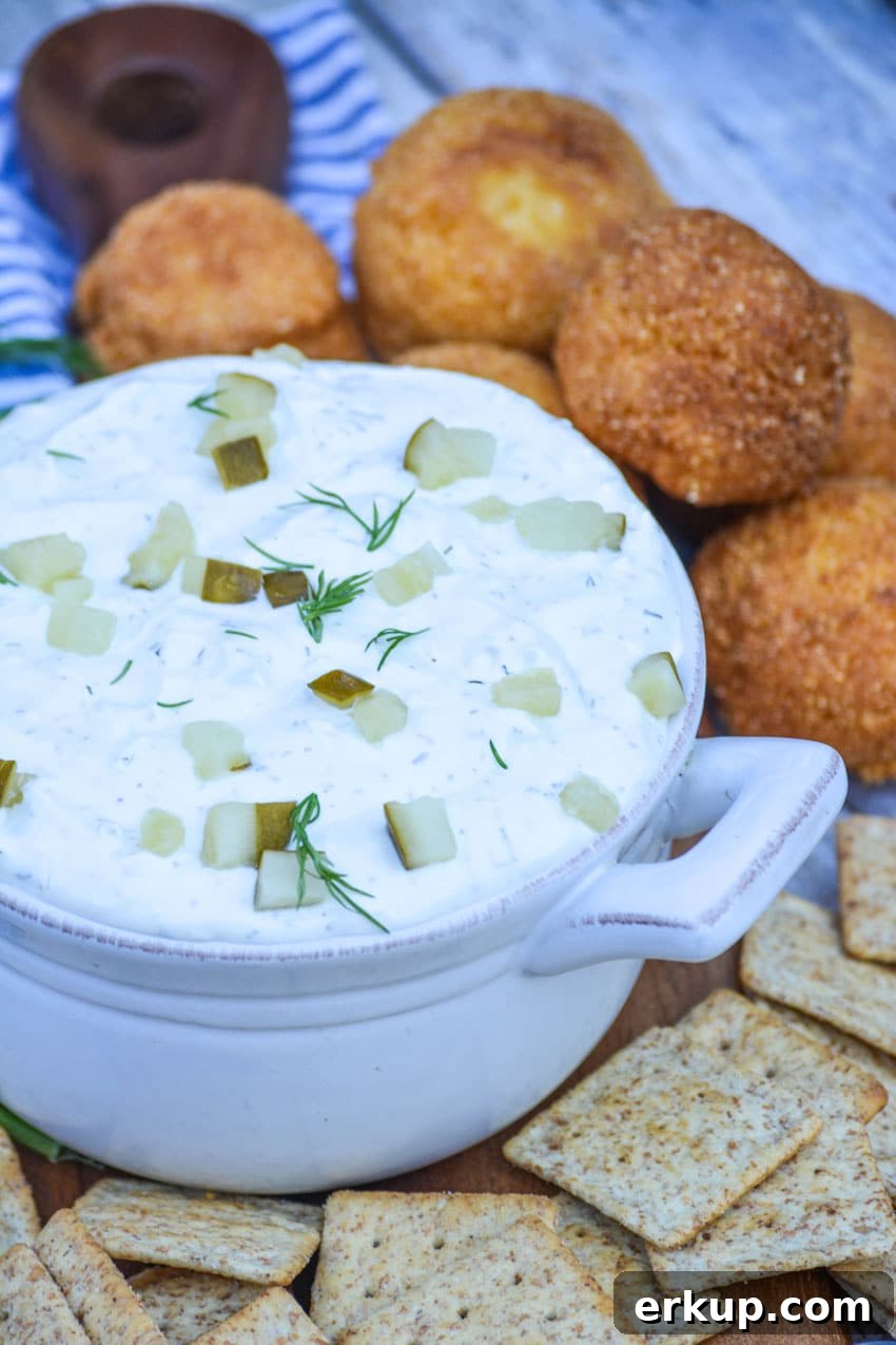 creamy dill pickle dip in a gray bowl surrounded by crackers