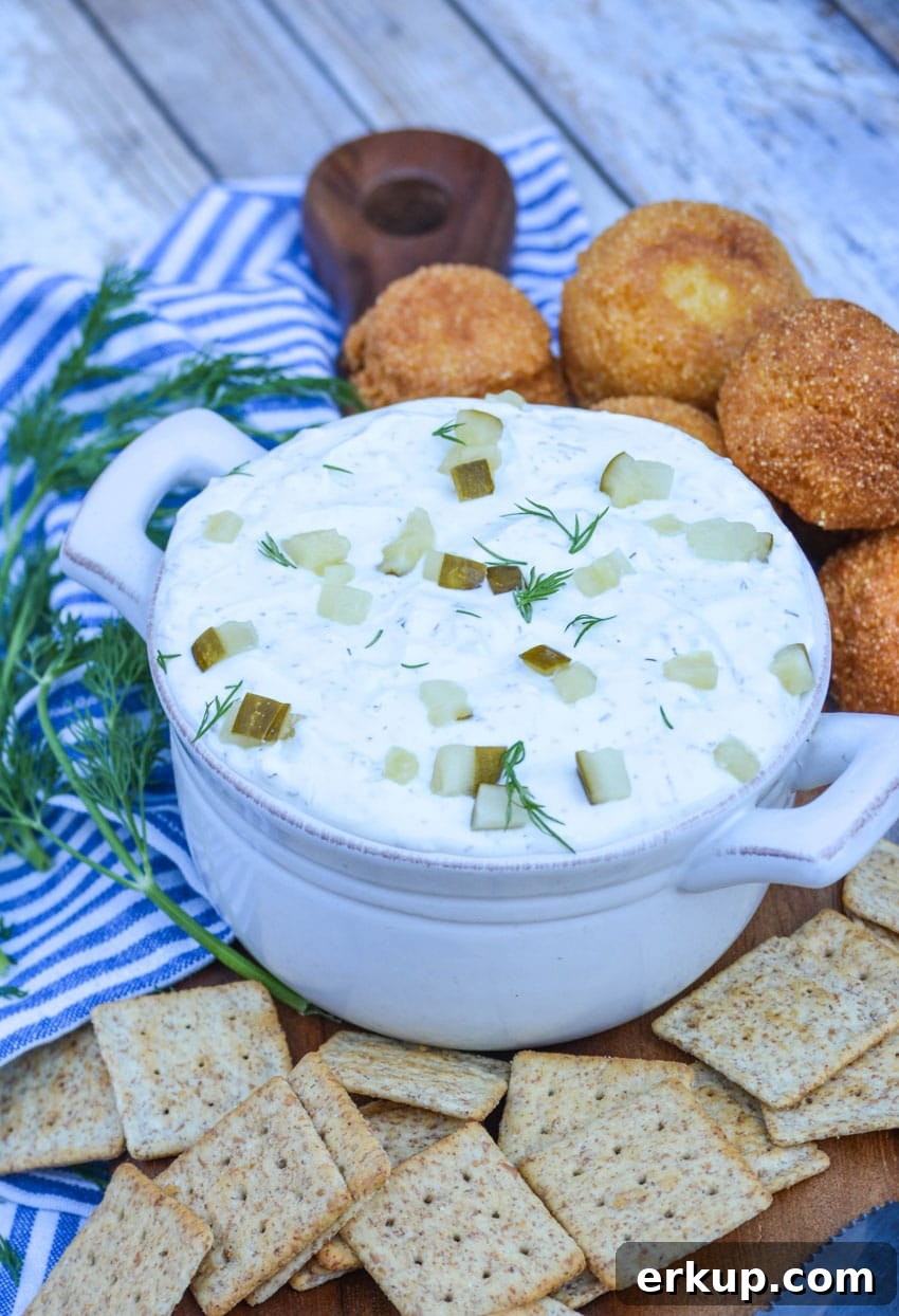 creamy dill pickle dip in a gray bowl surrounded by crackers