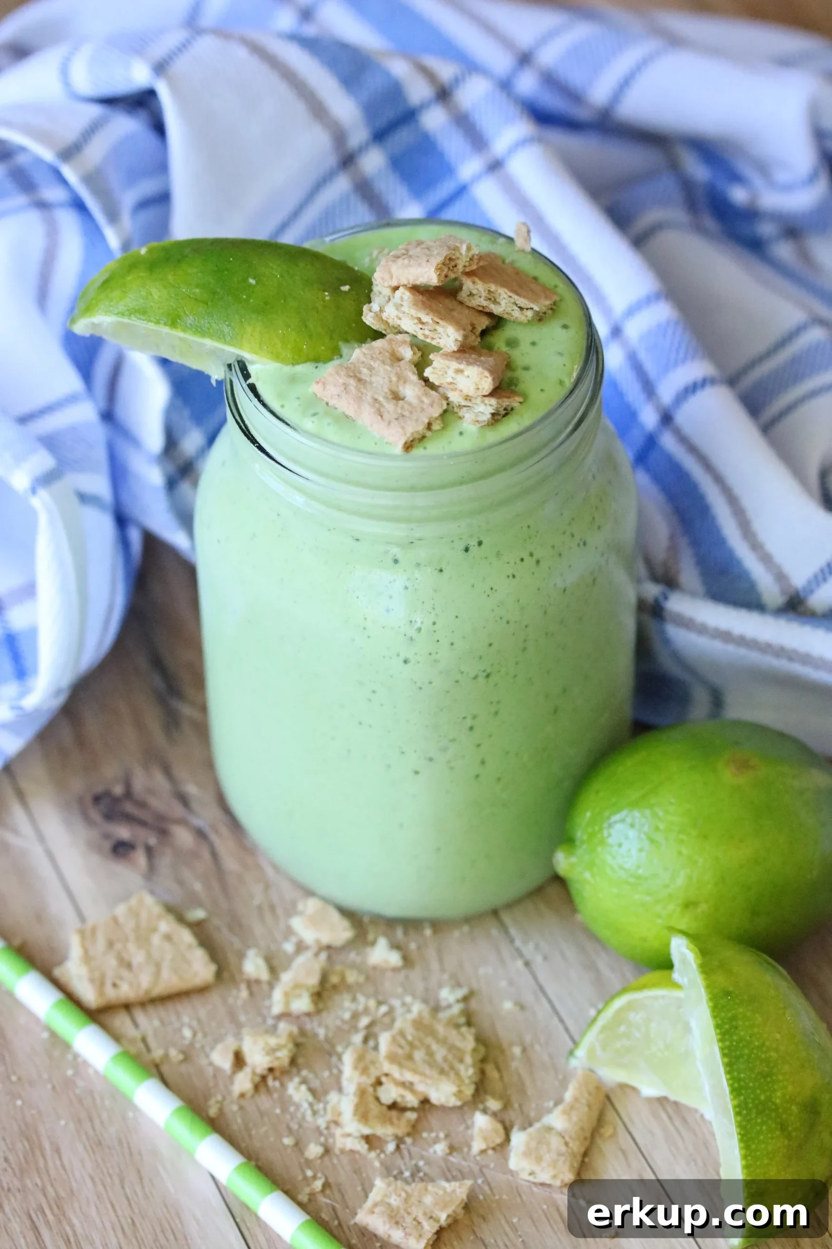 a green smoothie in a jar topped with graham crackers and lime