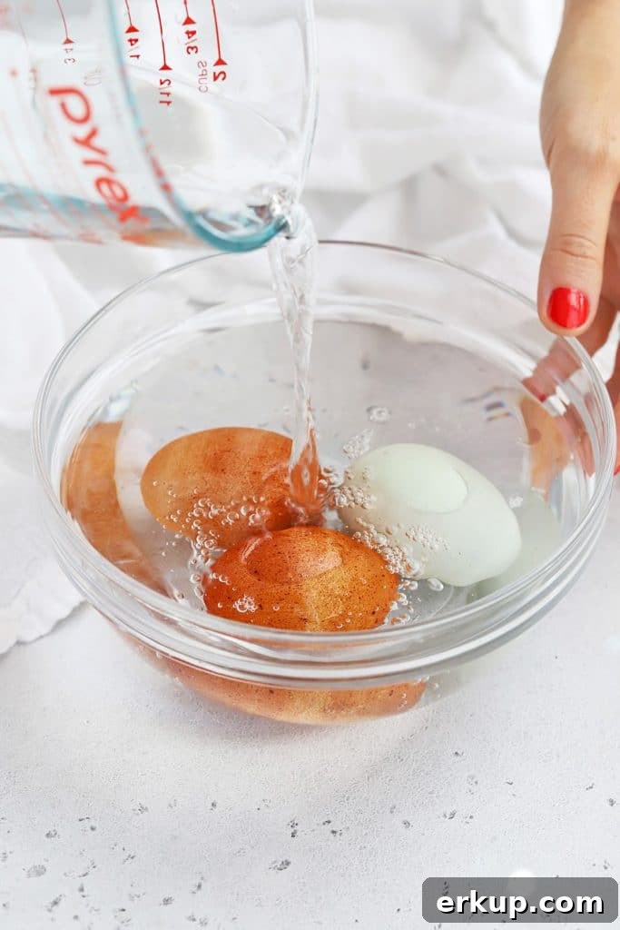Pouring water over eggs in a bowl to bring them to room temperature