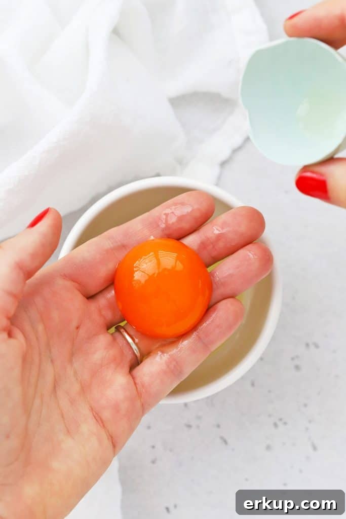 Overhead view of using your hand to separate egg yolks and egg whites