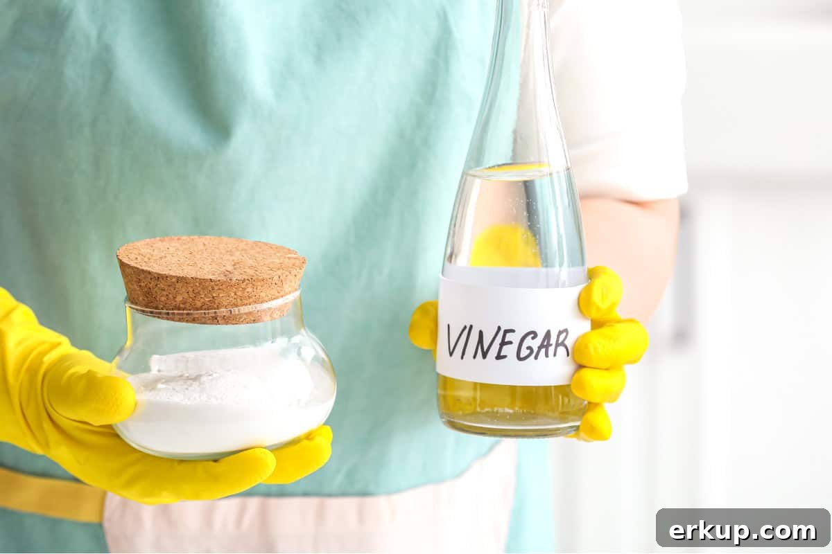 a person holding a jar of baking soda and a glass bottle of vinegar