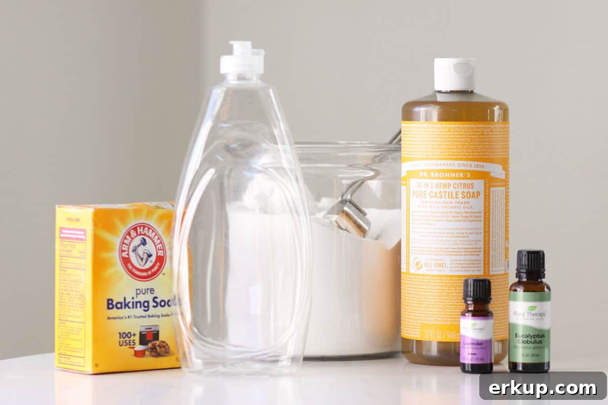 baking soda, castile soap, borax, essential oils and an empty dish soap squeeze bottle on counter