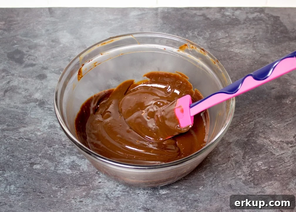 dark chocolate ganache in a glass bowl with a spatula