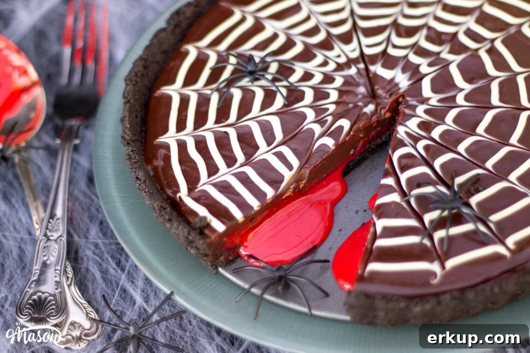 Halloween Dessert | No Bake Bloody Spider Web Chocolate Tart on a plate with plastic spiders
