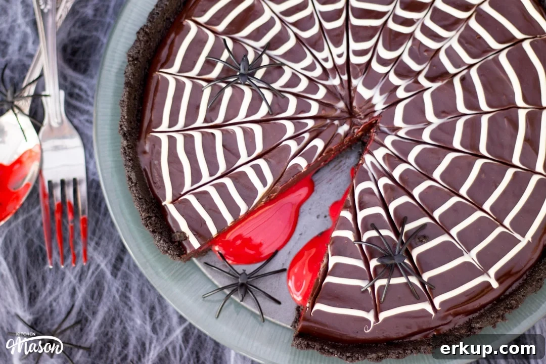 Halloween Dessert | No Bake Bloody Spider Web Chocolate Tart on a plate with plastic spiders