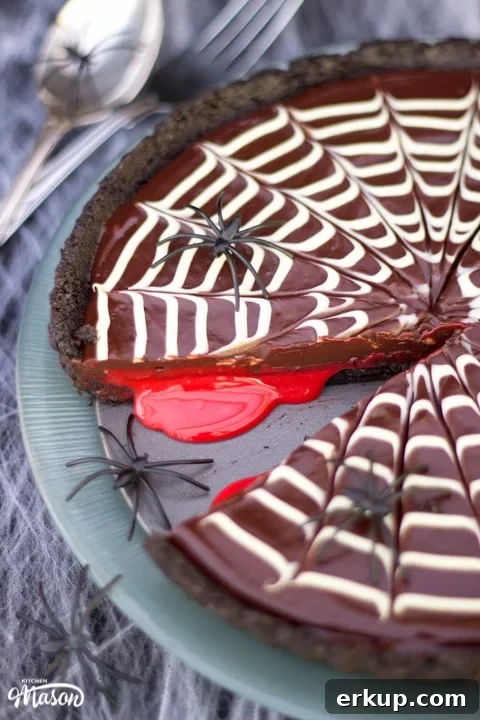 Halloween Dessert | No Bake Bloody Spider Web Chocolate Tart on a plate with plastic spiders