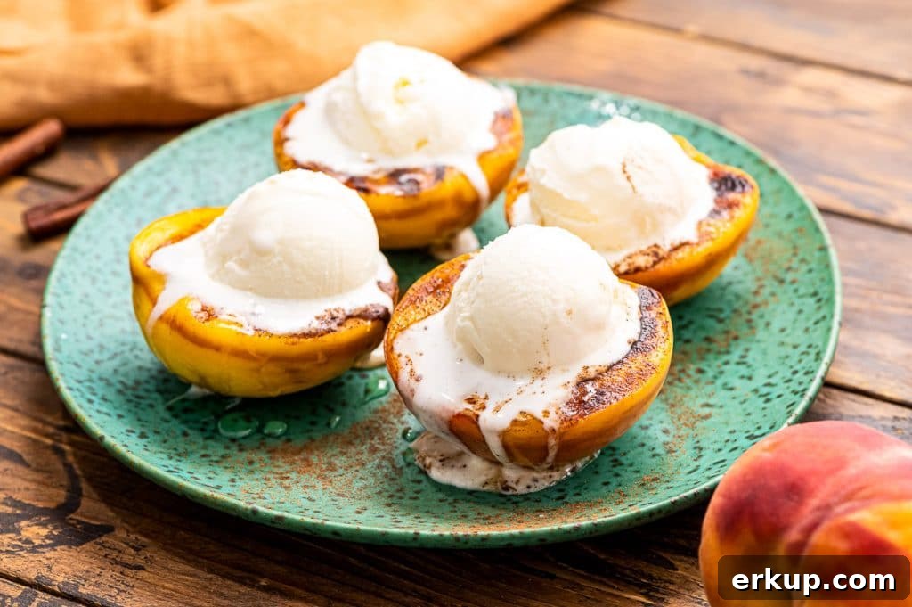 Green plate with grilled peaches topped with ice cream on it.