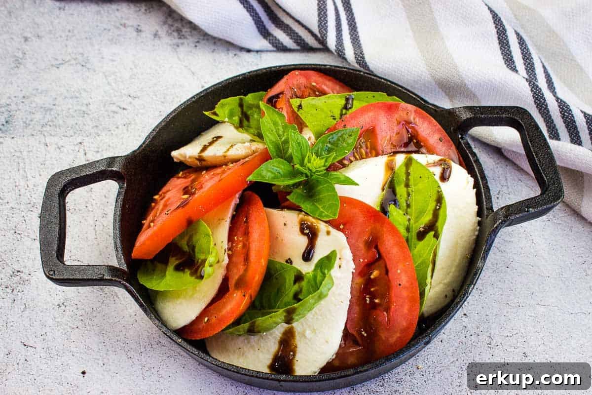 A top-down shot of a classic caprese salad in a black dish.