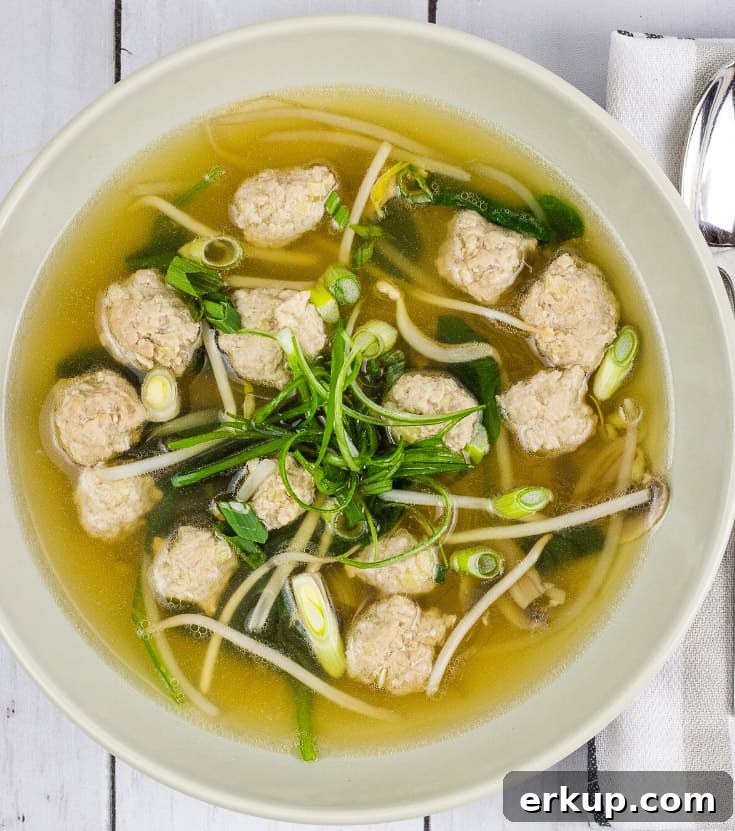 A bowl of Keto Wontonless Soup on a white wooden table.