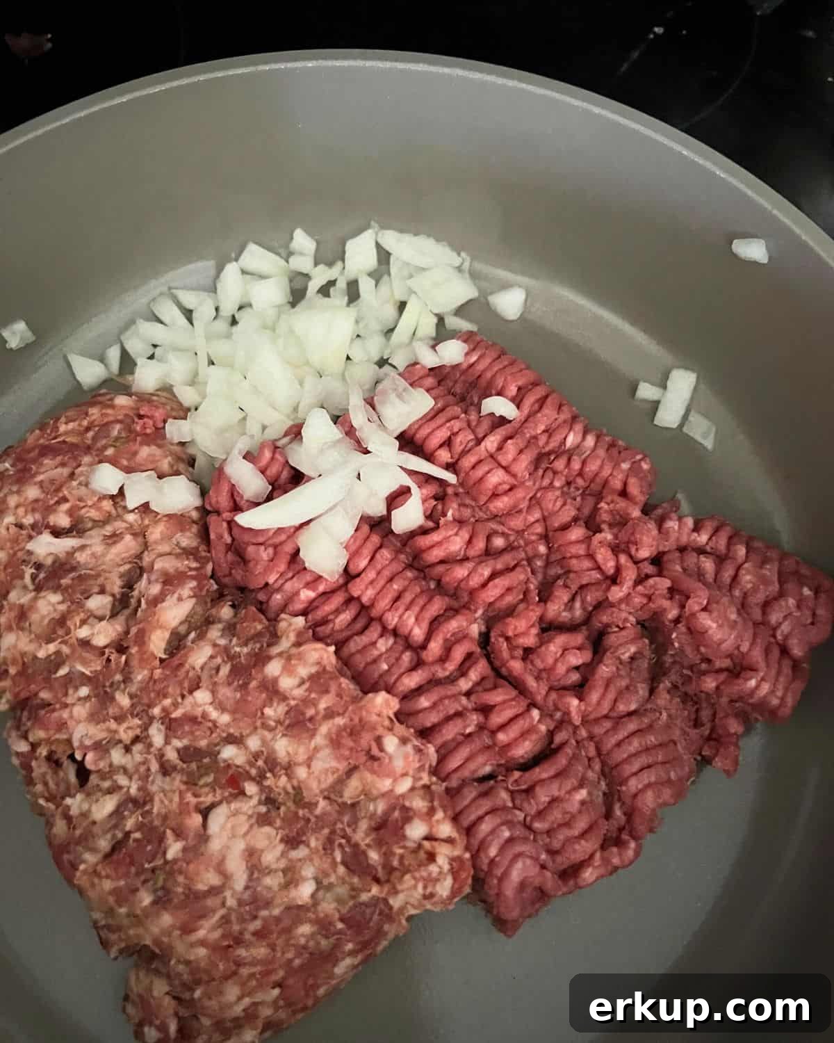Beef and onions cooking on a skillet.