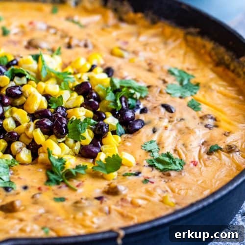 Queso in a black skillet on a dark blue counter.
